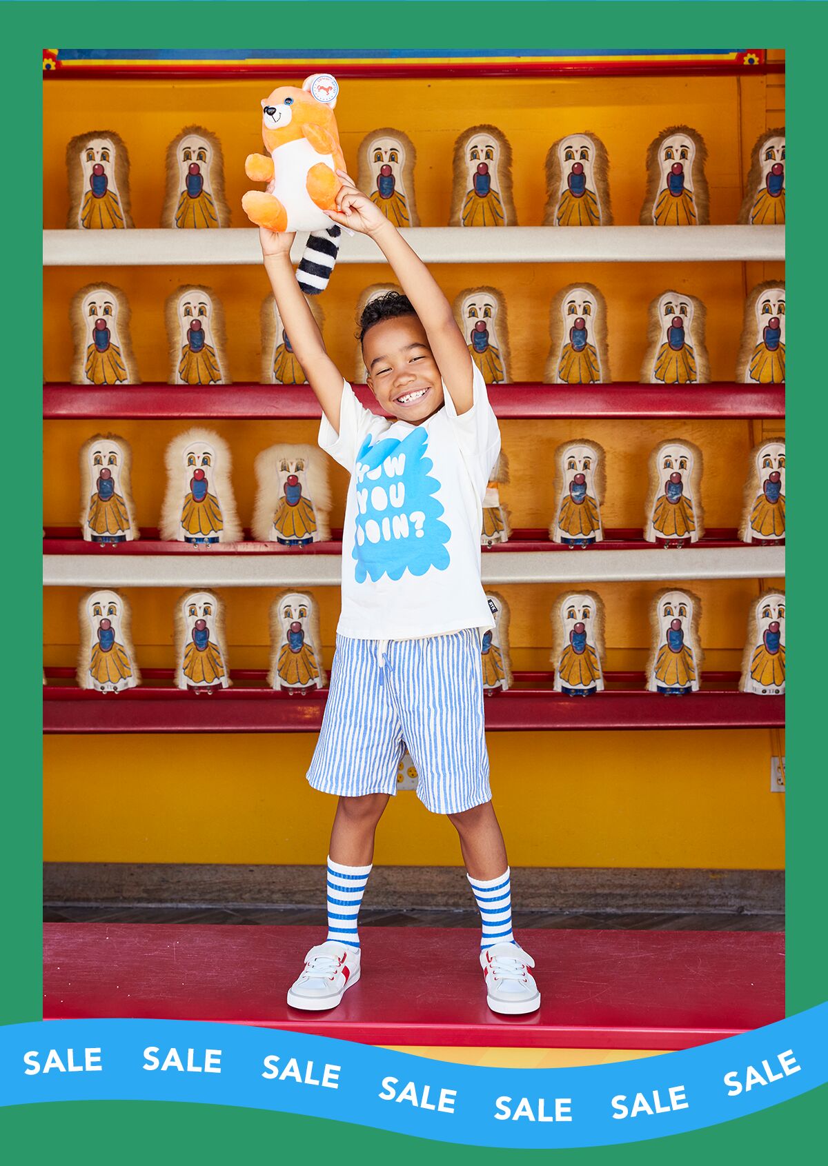 Boy at a carnival game, holding up a teddy bear